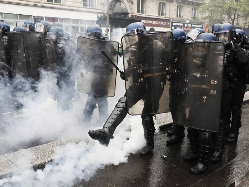 Paris (France), 01/05/2023.- A riot police kicks a tear gas canister during clashes at the annual May Day march in Paris, France, 01 May 2023. Despite the Constitutional Council's adoption of the law on 14 April raising the retirement age in France from 62 to 64 years old, protests against pension reform are being held in France on this International Workers' Day. Following the filing of a new appeal by the left-wing senators, a new decision is expected on 03 May. (Protestas, Francia) EFE/EPA/CHRISTOPHE PETIT TESSON