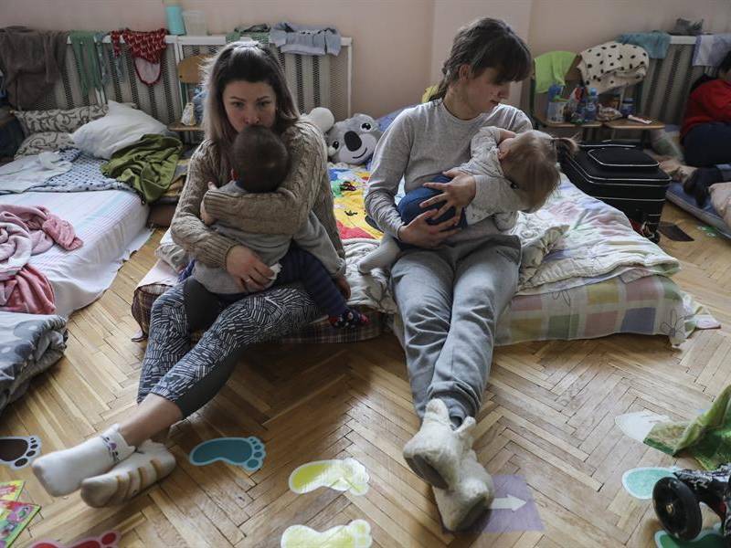 Dos madres y sus hijos descansan en una escuela infantil en Pustomyty, cerca de Leópolis, en el oeste de Ucrania, habilitada como refugio.