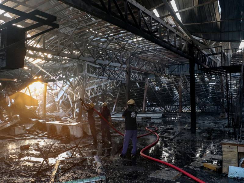 Bomberos apagan el incendio estructural en el parque de diversiones.