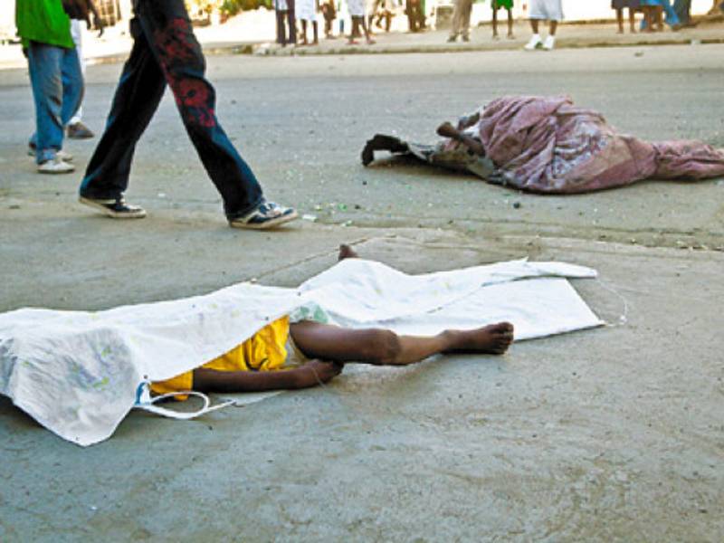 The bodies of two cholera victims lie in a street of Cap-Haitien on November 19, 2010 after four days of riots between demonstrators and UN peacekeepers accused of bringing cholera to the country. Preparations for key upcoming elections pressed ahead despite violent clashes with UN troops blamed by Haitians for importing a cholera epidemic that has now claimed nearly 1,200 lives. AFP PHOTO/JULIEN TACK