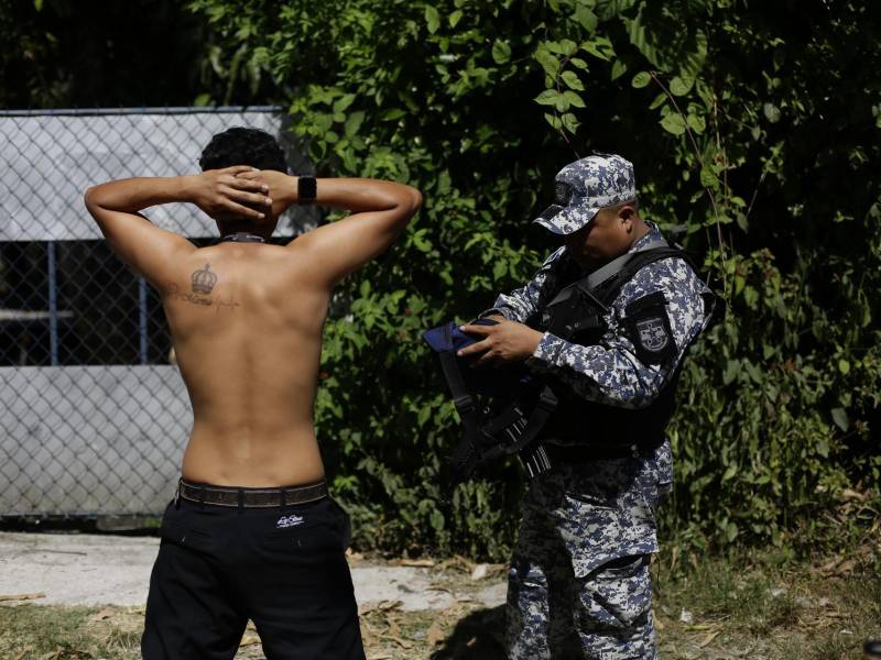 -FOTODELDÍA- AME7851. SOYAPANGO (EL SALVADOR), 03/12/2022.- Un policía salvadoreño realiza hoy una requisa en Soyapango (El Salvador). Unos 10.000 miembros de la Fuerza Armada y de la Policía Nacional Civil (PNC) fueron desplegados en el municipio populoso de Soyapango para extraer a pandilleros que aún no han sido capturados y continuar la guerra contra las pandillas. EFE/ Rodrigo Sura