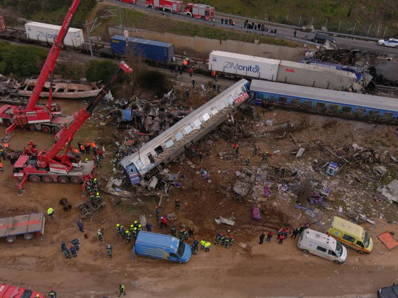 This aerial drone photograph taken on March 1, 2023, shows emergency crews examining the wreckage after a train accident in the Tempi Valley near Larissa, Greece. - At least 32 people were killed and another 85 injured after a collision between two trains caused a derailment near the Greek city of Larissa late at night on February 28, 2023, authorities said. A fire services spokesman confirmed that three carriages skipped the tracks just before midnight after the trains -- one for freight and the other carrying 350 passengers –- collided about halfway along the route between Athens and Thessaloniki. (Photo by STRINGER / AFP)