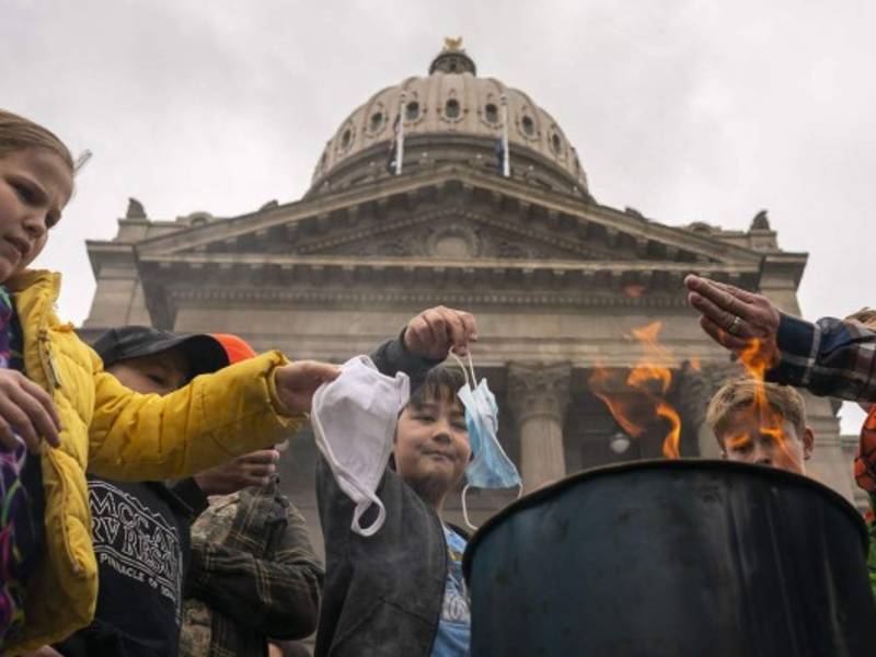 Un grupo de niños queman mascarillas quirúrgicas durante una manifestación contra las restricciones por la pandemia en Idaho./AFP.
