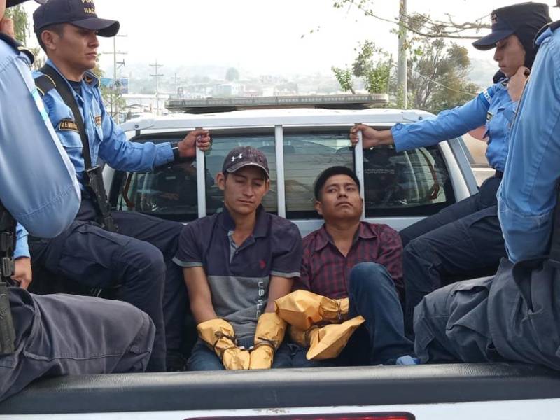 Dos de los sospechosos de participar en la masacre capturados por agentes de la Policìa.