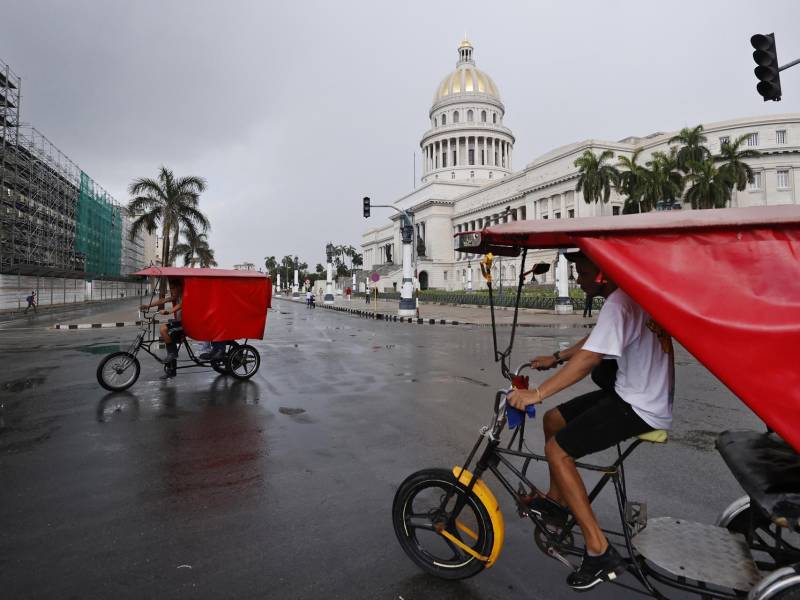 Un par de bicitaxis captados en julio frente al Capitolio de La Habana (Cuba). EFE/Ernesto Mastrascusa.