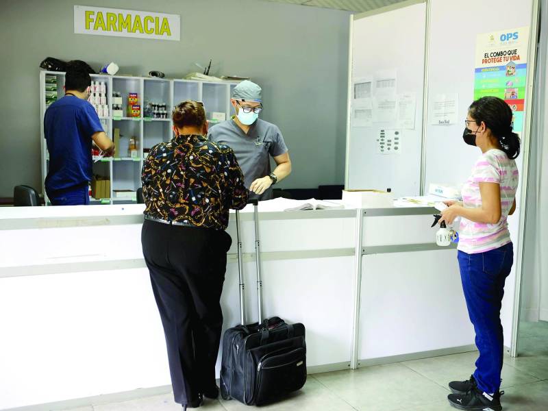Dos pacientes esperan por medicinas en el triaje del Infop, donde están recibiendo de ocho a 10 consultas diarias.