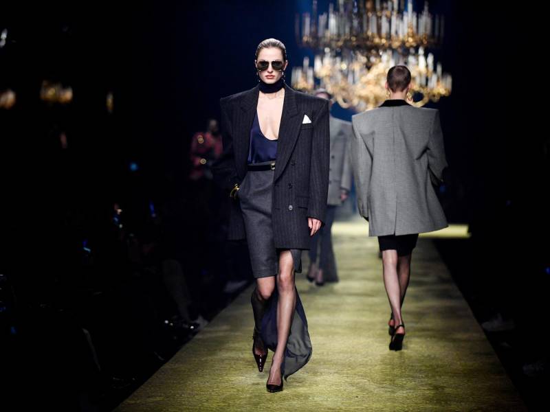 En una pasarela iluminada por candelabros, las modelos esbeltas y de largas piernas desfilan con gafas de sol. En primera fila, la gurú de la moda, Anna Wintour, se pone las suyas cuando empieza el espectáculo.