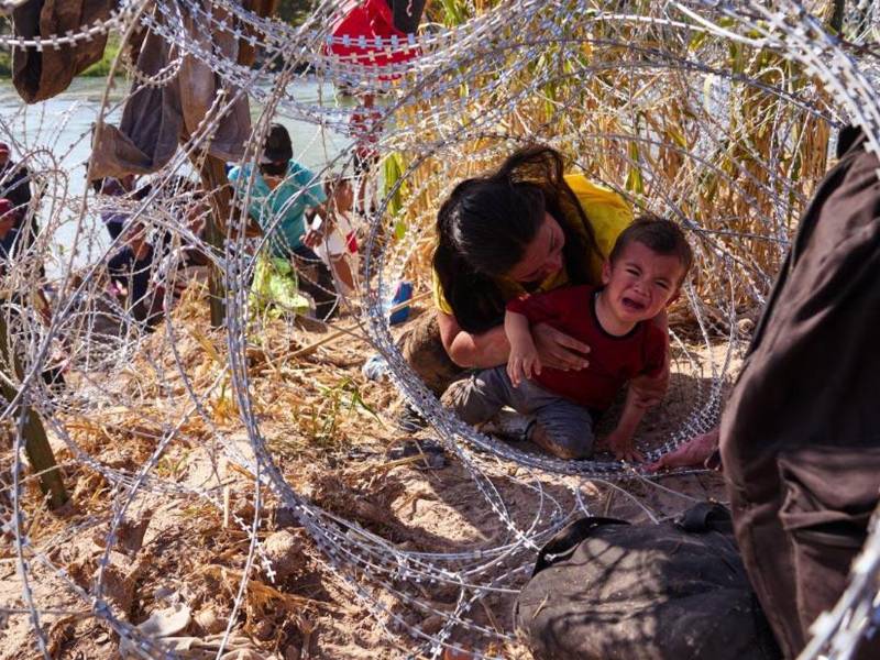 Un niño llora mientra cruza la frontera de Estados Unidos.