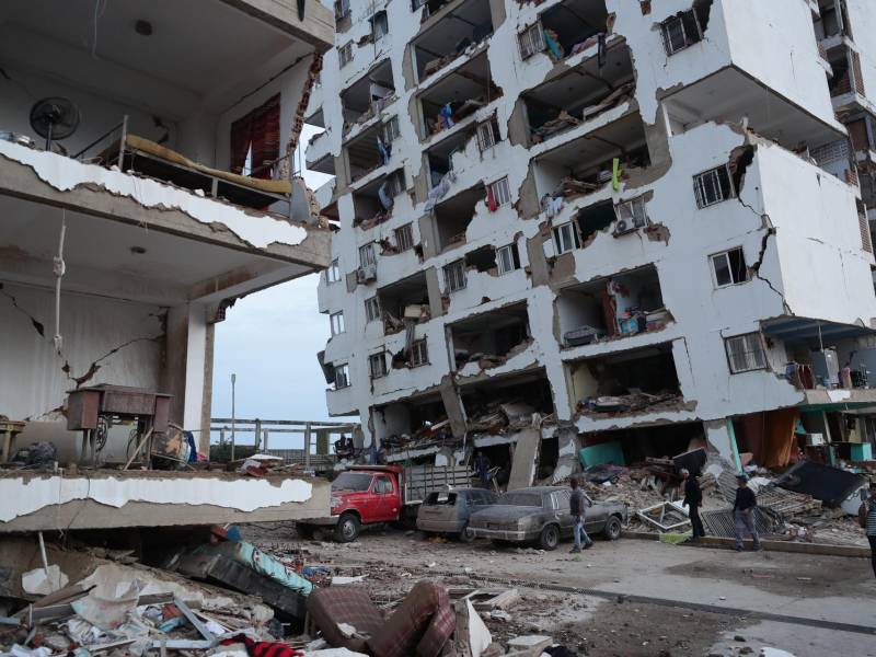 Residentes caminan entre los escombros de varios bloques de viviendas dañados por los terremotos en la localidad de Catia La Mar, en el estado costero de La Guaira (Venezuela).