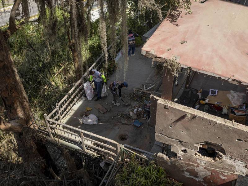 Trabajadores gubernamentales limpian escombros de una casa afectada tras ataque de EE.UU., el martes, en Caracas, Venezuela.