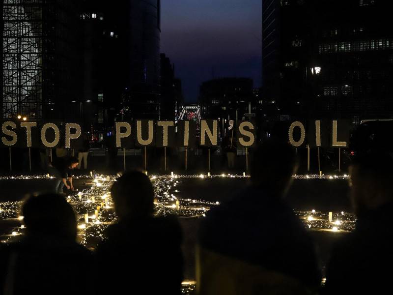 Activistas ucranianos protestan en Bruselas con un letrero que pide “detener el petróleo de Putin”.