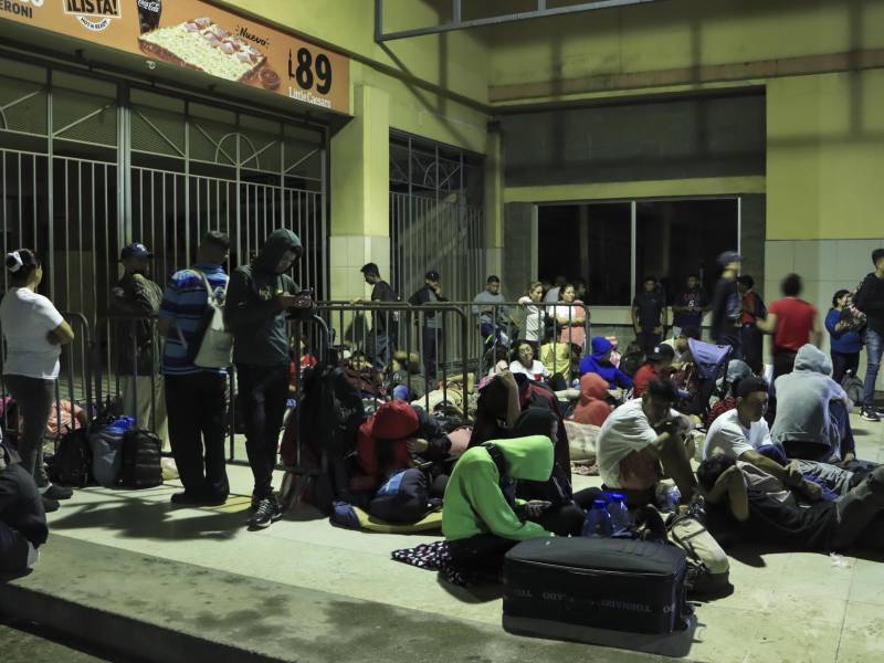 Migrantes de diferentes nacionalidades descansan en la Gran Central Metropolitana donde se preparan para salir en caravana con destino a los Estados Unidos, hoy en la ciudad San Pedro Sula (Honduras).
