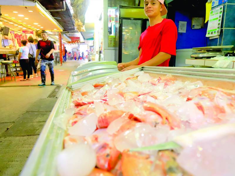<b>Un joven trabaja en una pescadería del mercado Dandy en San Pedro Sula. Fotos: Melvin Cubas.</b>