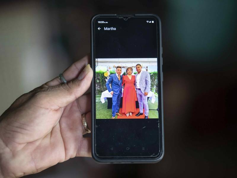 Un familiar de Martha Alejandra Hernández Zamora muestra una fotografía con sus hijos, Sergio Silva Hernández (i), y Erick Salomón Torres Hernández (d), victimas de un incendio en una discoteca en la ciudad de Murcia (España).