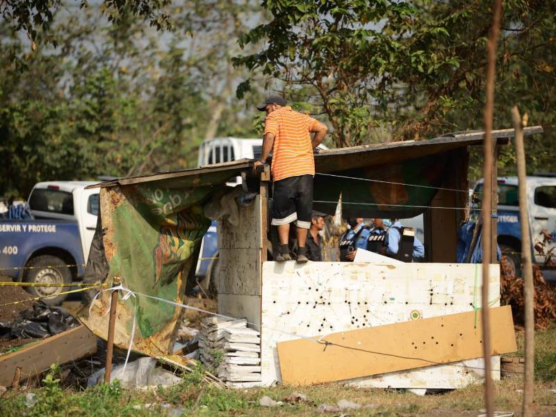 Hombre comienza a desarmar su covacha ante la presión de los agentes de la Policía Nacional.