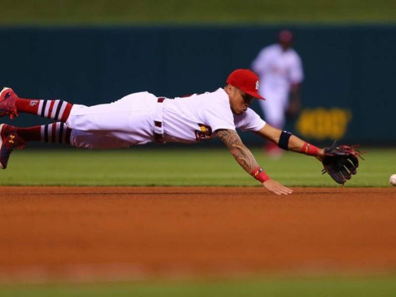BÉISBOL. Lanzada de un cardenal. Kolten Wong, de los Cardenales de St. Louis, intenta atrapar la pelota al ras de la tierra en la tercera entrada frente a los Padres de San Diego en el Busch Stadium en St. Louis, Missouri.
