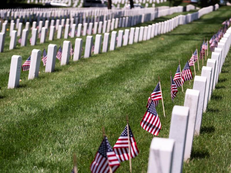 El cementerio nacional de Arlington adornado con banderas estadounidenses en las tumbas de los soldados caídos.