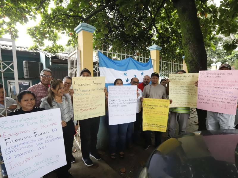 Empleados con pancartas en el portón del INA en San Pedro Sula.