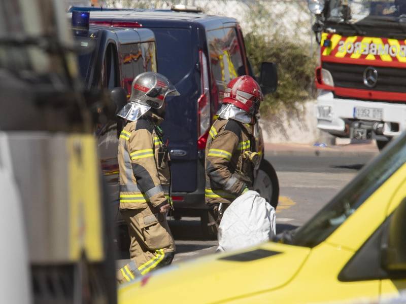 Dos bomberos durante las labores de rescate de los cuerpos de los fallecido en el incendio.