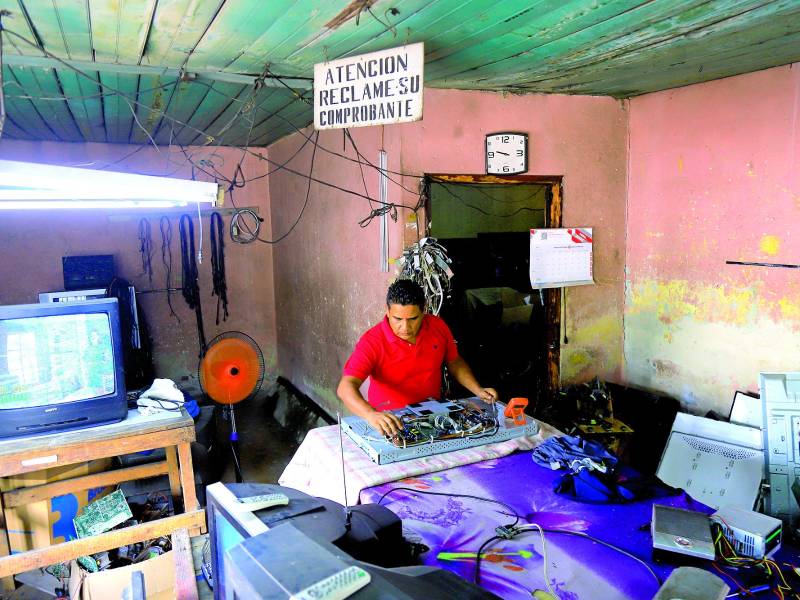 El taller de Ezequiel está lleno de aparatos por reparar.