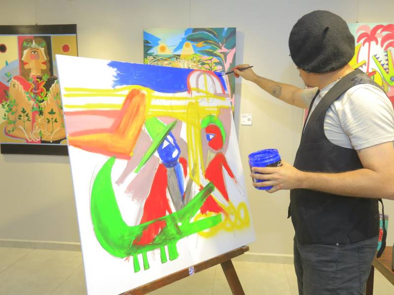 El artista y arquitecto hondureño Carlos Lamothe mientras realizaba su obra frente a la curiosa vista de los asistentes.