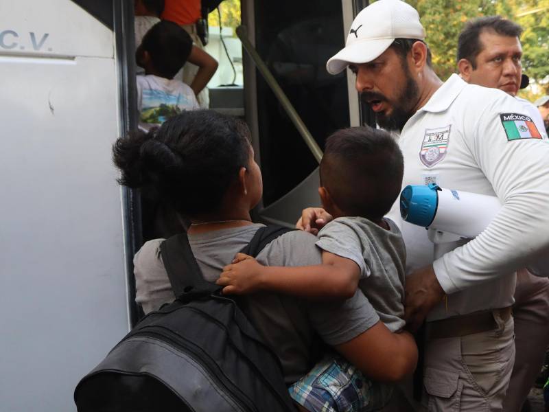 Una migrante con su hijo conversa con un oficial del Instituto Nacional de Migración (INM) antes de abordar un autobús en el municipio de Mapastepec, estado de Chiapas.