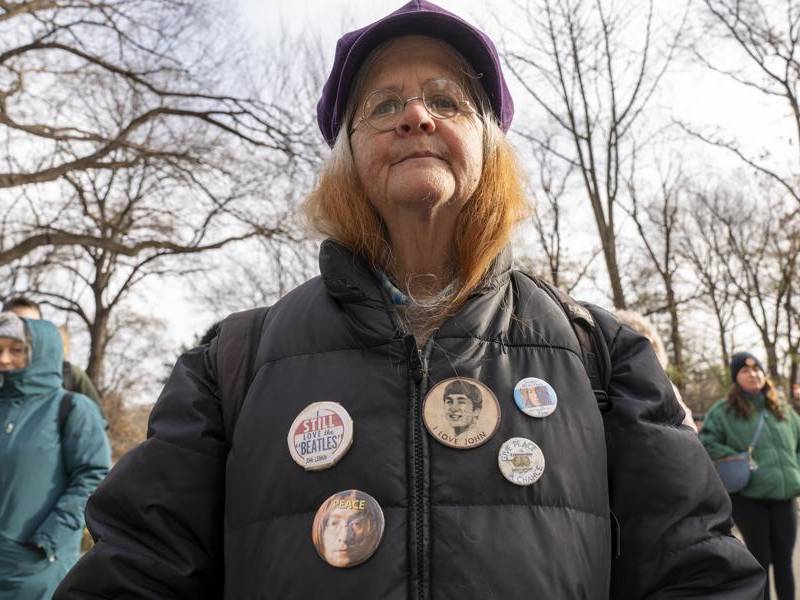 Una persona porta pines con la imagen de John Lennon durante una conmemoración por los 45 años de su muerte este lunes, en Nueva York (EE.UU.).
