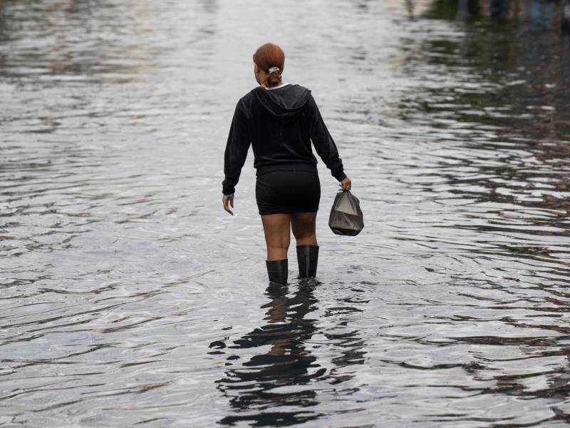 Una mujer camina por una zona inundada este jueves, en Santo Domingo (República Dominicana).