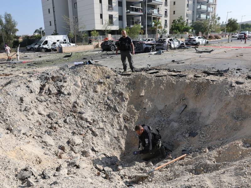 Unidades de desactivación de explosivos de la policía buscan restos en el lugar donde misiles balísticos iraníes impactaron contra edificios residenciales en Beersheba.