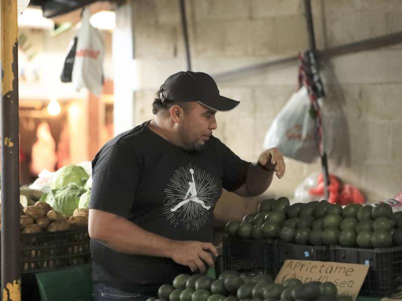Edwin Rivas trabaja en su puesto de venta de verduras en la feria del agricultor y el artesano el 22 de diciembre de 2025 en Tegucigalpa.