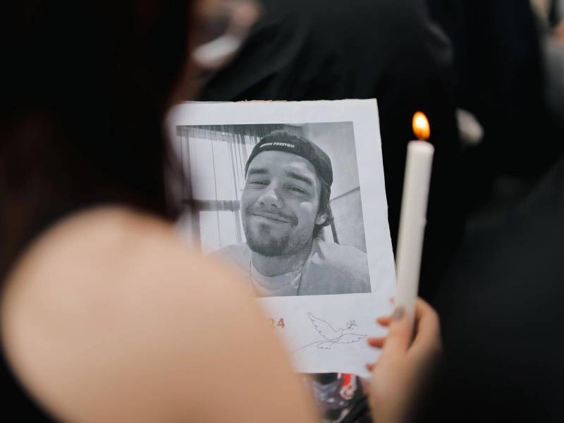 Una fan aprecia una fotografía del cantante británico Liam Payne, quien falleció en octubre de 2024.
