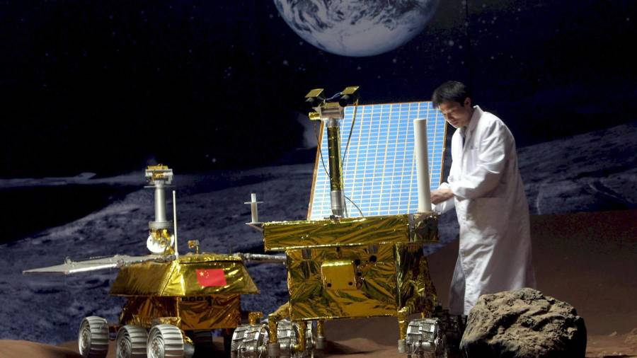 $!Imagen de archivo de un investigador chino trabaja en un prototipo de vehículo lunar en una superficie simulada.