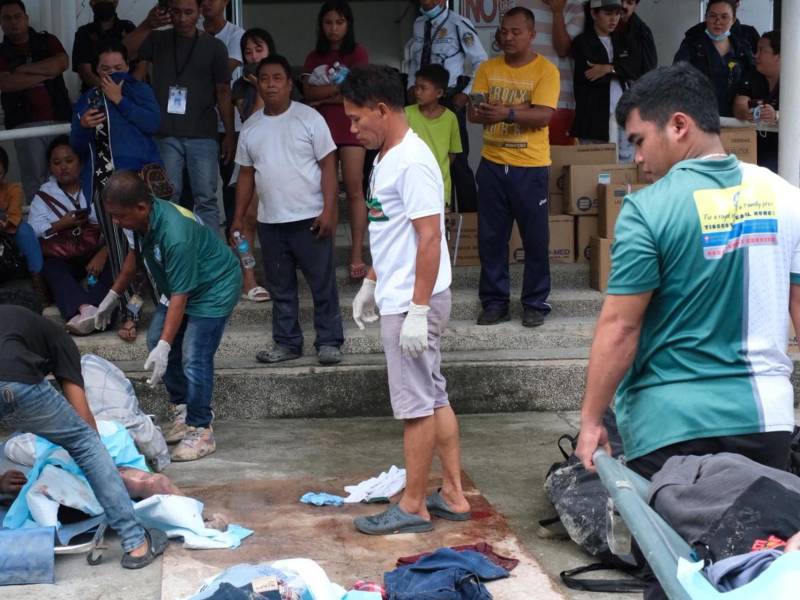 Un grupo de filipinos con una víctima del terremoto que azotó el archipiélago.