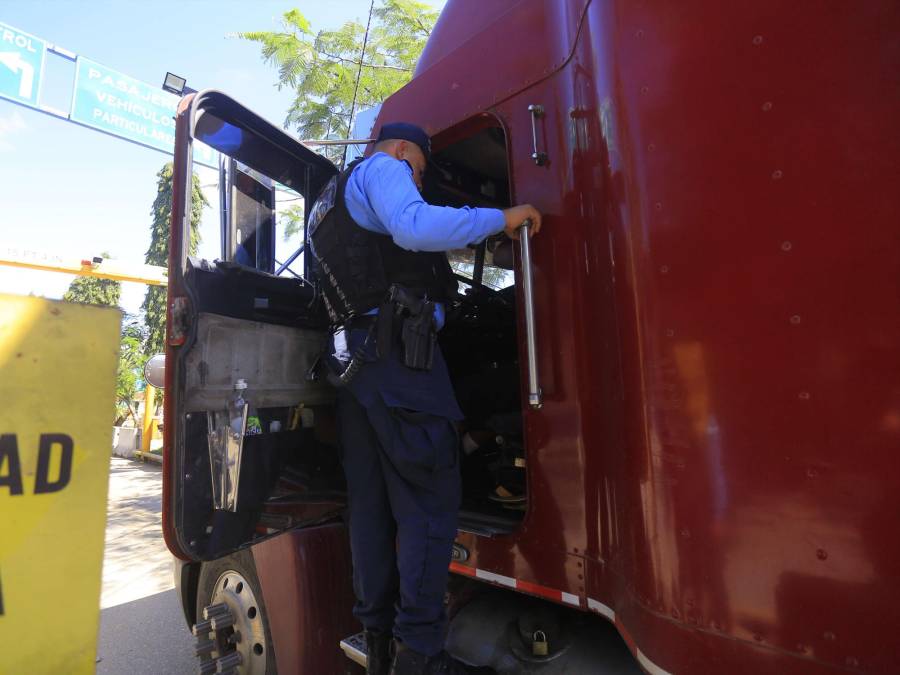 Un oficial inspecciona y requiere a un conductor de tráiler en Corinto. 