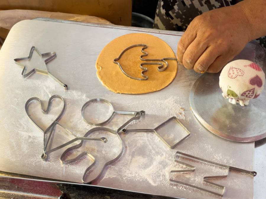 Luego de derretir unas tres cucharadas de azúcar con media cucharadita de bicarbonato en un cucharón o sartén pequeña, se da la forma deseada a la galleta con cortantes de formas infantiles.