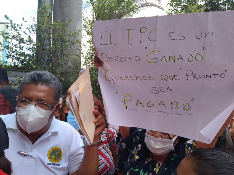Representantes del sindicato de la Secretaría de Infraestructura y Transporte sostienen pancartas de peticiones.