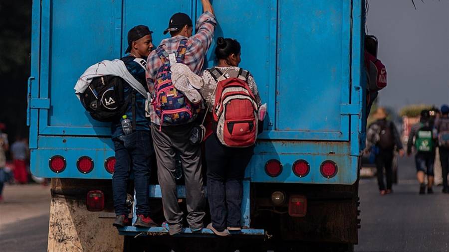 $!Migrantes se aferran a las puertas de un camión para avanzar en su recorrido hacia Ciudad de México.