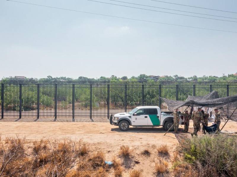 En una vista aérea, miembros de la Guardia Nacional están bajo la sombra mientras patrullan cerca de las orillas del río Grande en Eagle Pass, Texas.