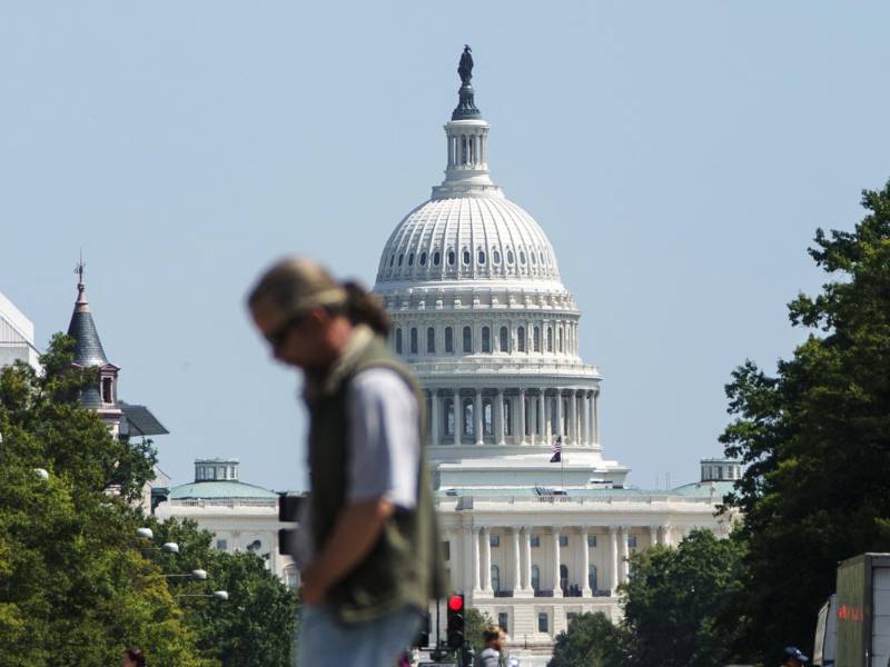 Foto de archivo que muestra a un transeúnte cruzando la avenida Pensilvania frente al Capitolio de los Estados Unidos, en Washington D. C.