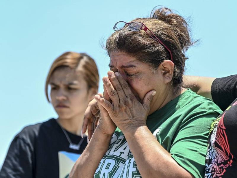 María López llora mientras visita un monumento improvisado en el lugar donde se descubrió el tráiler con migrantes adentro, en las afueras de San Antonio, Texas
