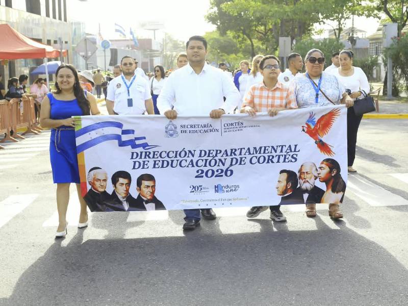 Autoridades educativas y docentes de la Dirección Departamental de Educación de Cortés participan en los desfiles cívicos del 14 de septiembre, portando una pancarta que conmemora los 205 años de independencia de Honduras.