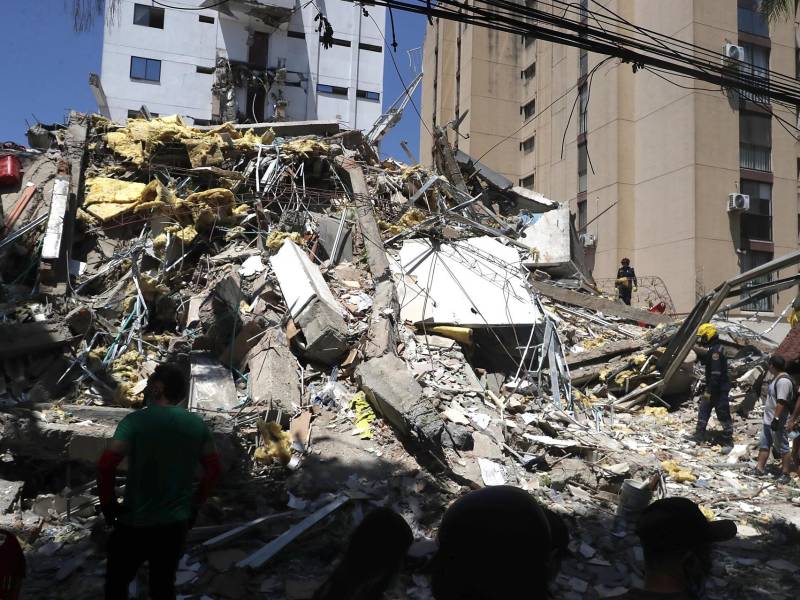 Integrantes del cuerpo de Bomberos de Cali y civiles buscan entre los escombros de edificaciones colapsadas por el terremoto de magnitud 7,4 que sacudió esta mañana el país, este lunes en Cali (Colombia).