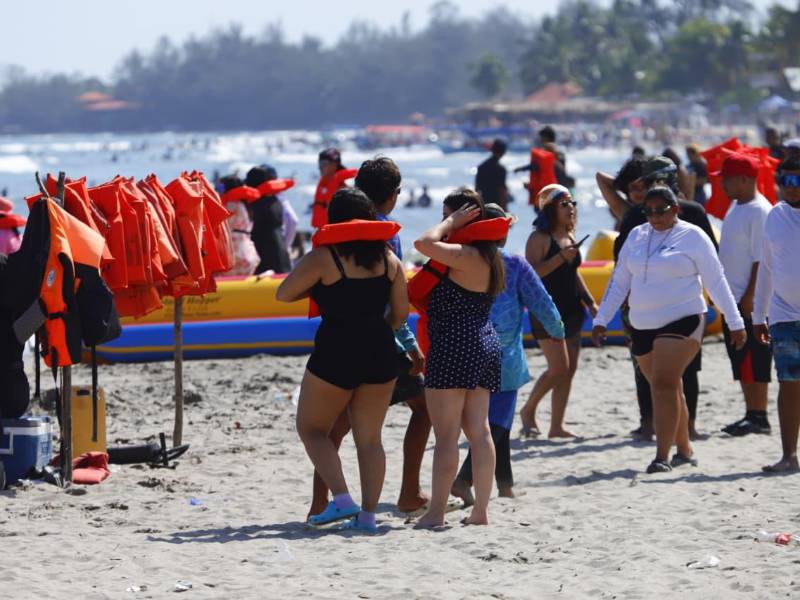 Turistas disfrutan de las cálidas aguas de Tela este sábado. El uso de chalecos salvavidas es obligatorio para las actividades acuáticas y paseos en lancha, como parte de las medidas de seguridad para los veraneantes. Foto: Héctor Emilio Paz.