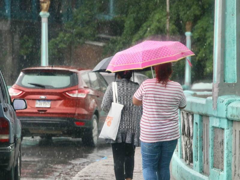 Ciudadanas caminan durante un día lluvioso en Tegucigalpa.