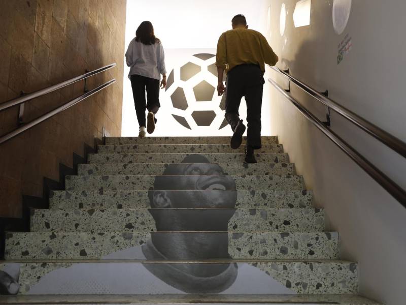 Personas caminan por una escalera con la imagen de Pelé este jueves, en Ciudad de México (México). EFE/ Sáshenka Gutiérrez
