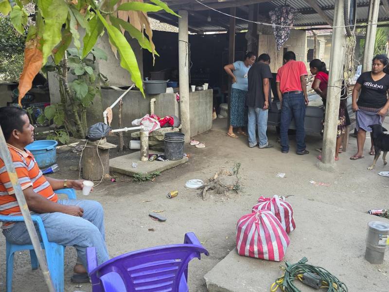 Familiares y amigos observan los féretros de los hermanos Elmer y Wilmer Suchite durante su velorio este viernes, en Rigores, Trujillo, Colón.