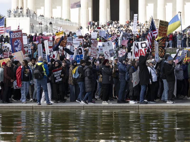 Activistas sostienen carteles y pancartas mientras participan en la marcha 'No Kings' (No reyes) en Washington.