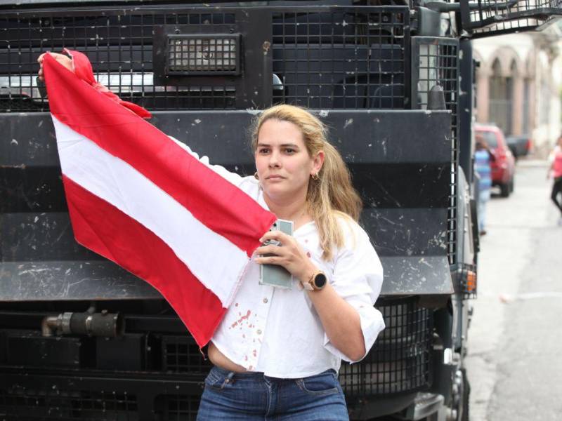 La dirigente liberal Julia Talbott alza la bandera de ese partido.
