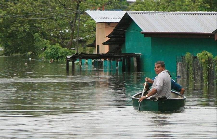 Un hombre se moviliza en una canoa en una colonia que fue inundada.
