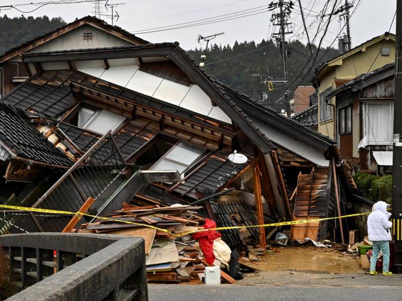 Rescatistas trabajan bajo la lluvia en busca de las personas atrapadas bajo escombros.